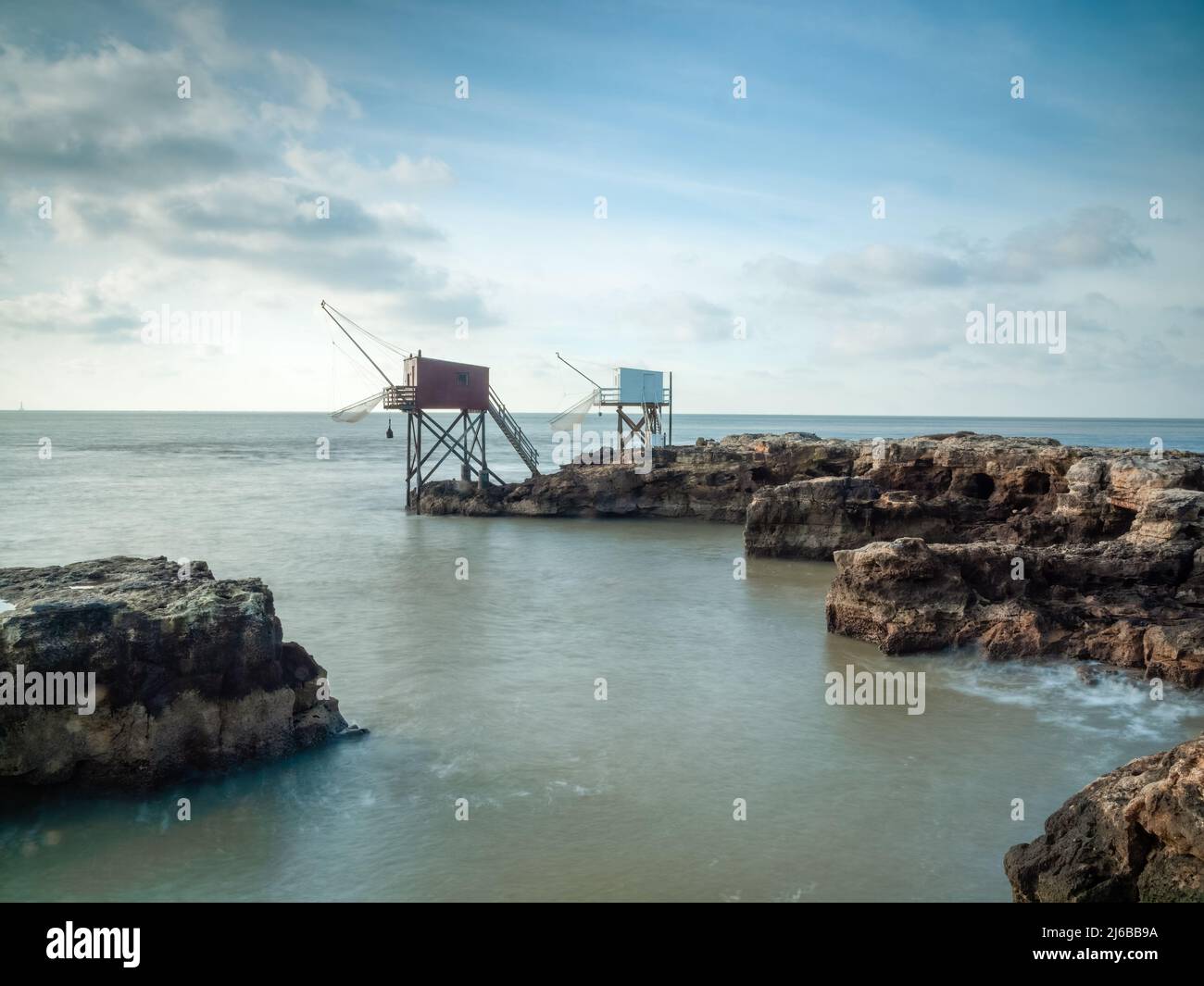 Due capanne di pesca sulla costa rocciosa della Charente-Maritime, Francia con acque calme e piatte dell'oceano Atlantico Foto Stock