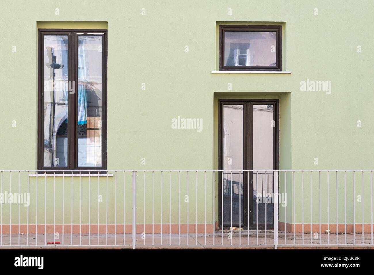 Facciata di un edificio verde con finestre in legno, minimalismo Foto Stock