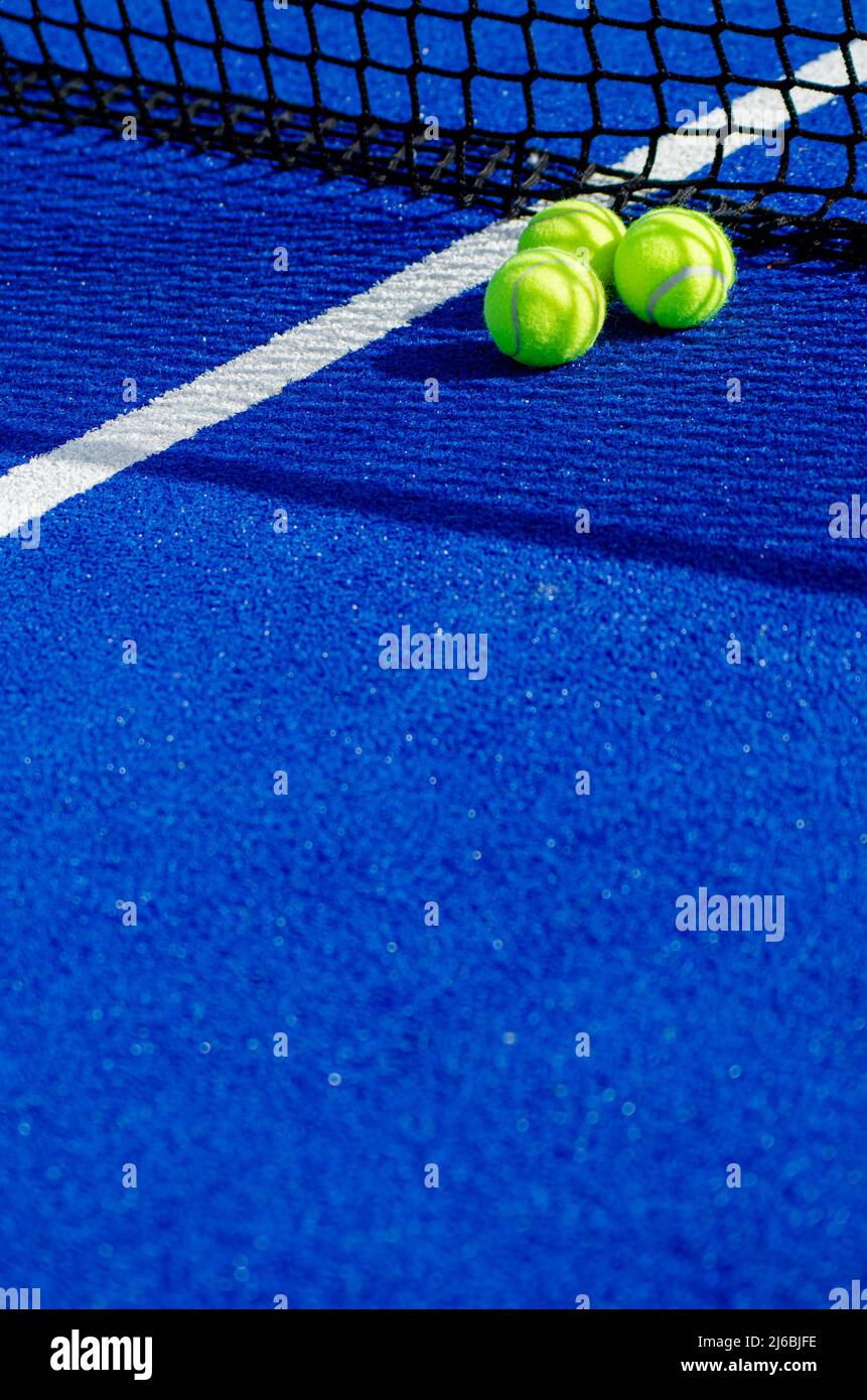Tre palle vicino alla rete di un campo da tennis in padel blu Foto Stock