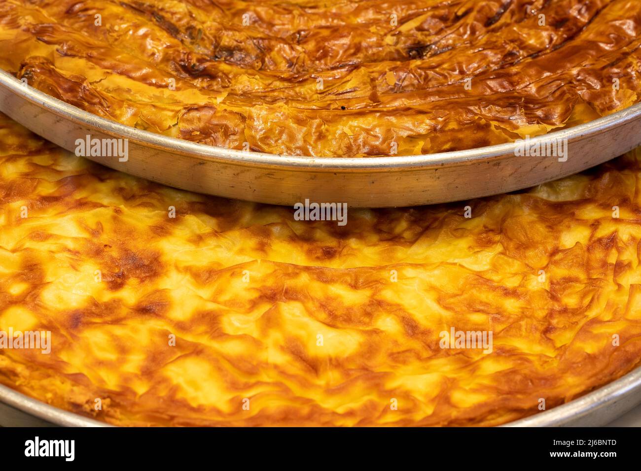 Vassoio di pasticceria. Pasta di burro e spinaci su sfondo bianco. Primo piano. Nome locale su boregi ve ispanakli borek Foto Stock