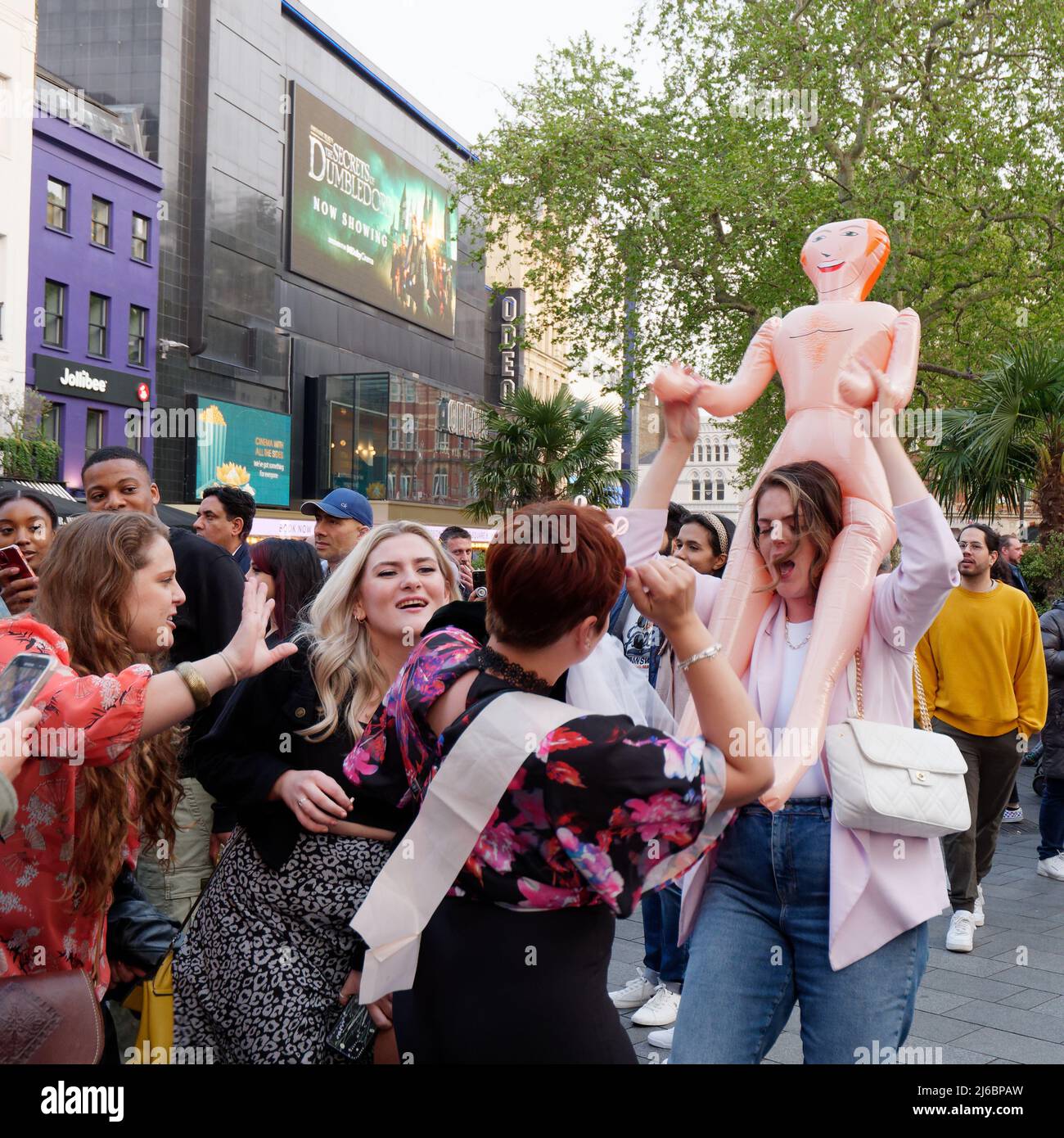 Londra, Greater London, Inghilterra, aprile 23 2022: Donne che si divertono su un Hen Party One che porta una bambola soffiare sulle spalle, in Leicester Square. Foto Stock