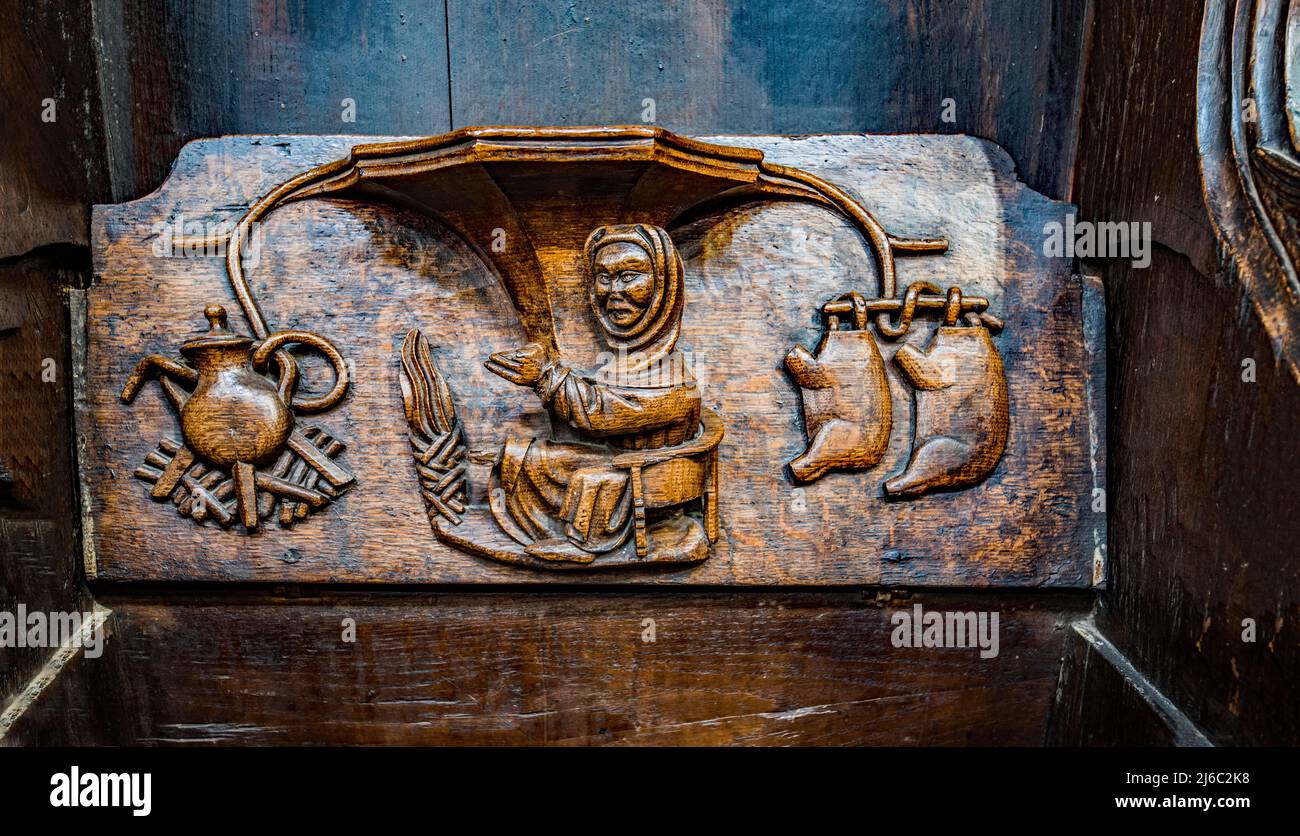 I Misericords sono piccole strutture di legno formate sul lato inferiore di una sede pieghevole in una chiesa. Qui visto nella chiesa parrocchiale di St Laurence a Ludlow. Foto Stock