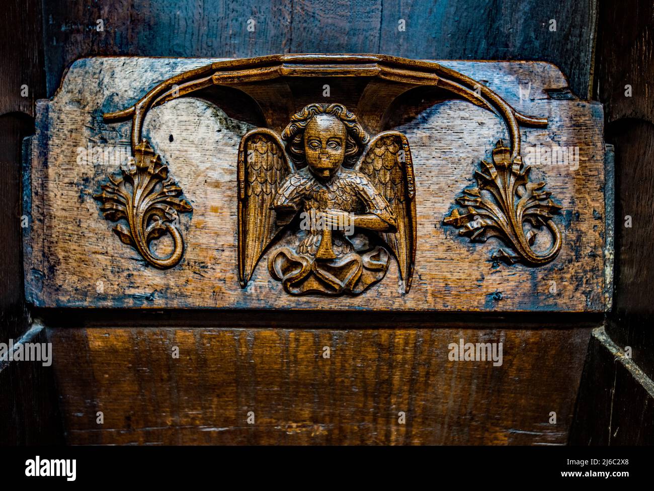 I Misericords sono piccole strutture di legno formate sul lato inferiore di una sede pieghevole in una chiesa. Qui visto nella chiesa parrocchiale di St Laurence a Ludlow. Foto Stock