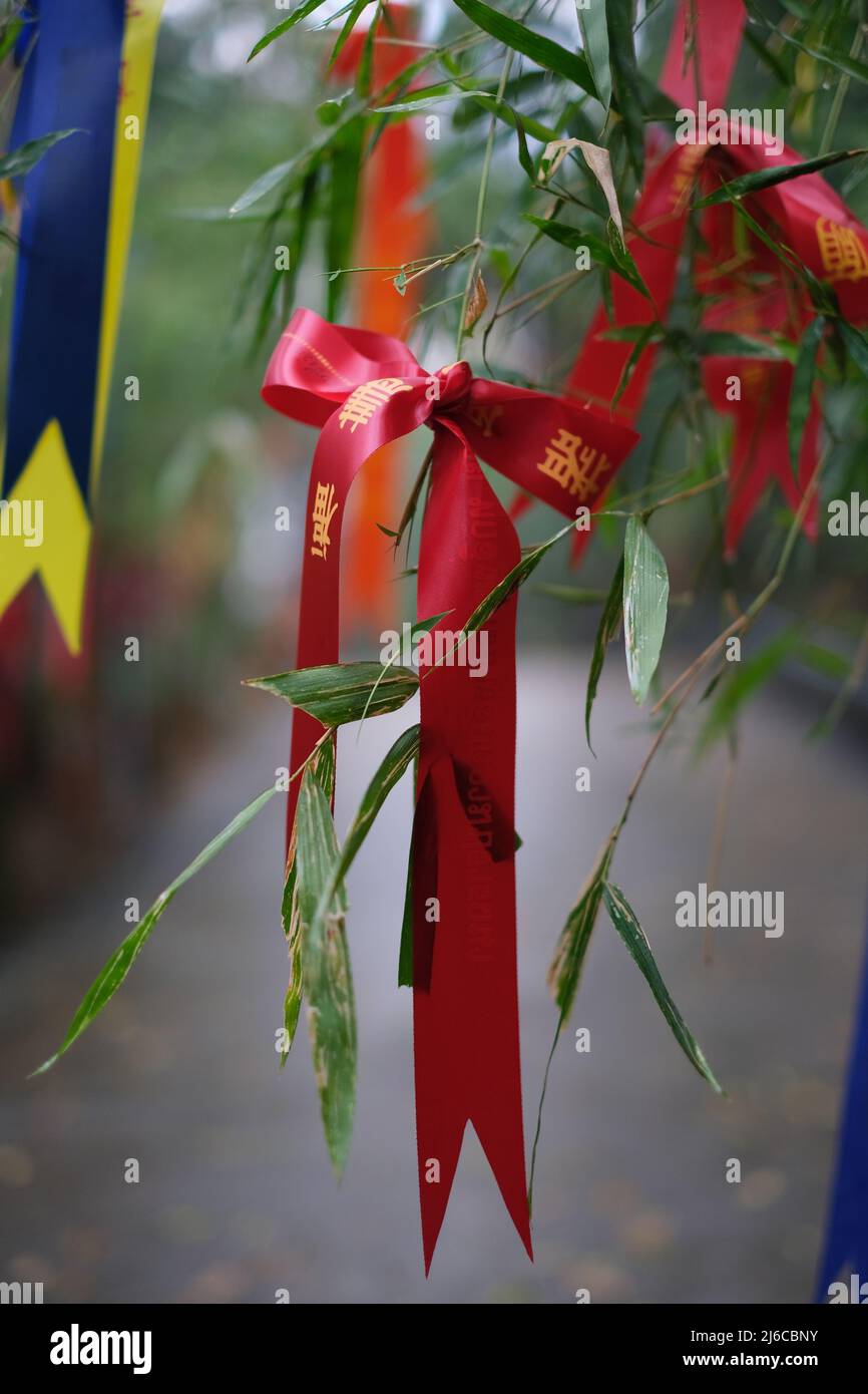 Un fascio di bande colorate con i migliori auguri all'ingresso del tempio buddista in Thailandia Foto Stock