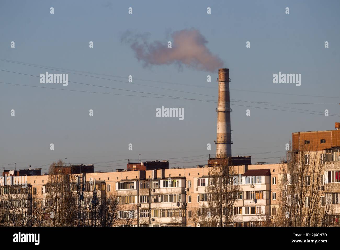 Tubi di una vecchia fabbrica gettano nuvole di fumo bianco velenoso nel cielo inquinando l'atmosfera. Smog urbano da fumo dalle caldaie. Bianco s. Foto Stock