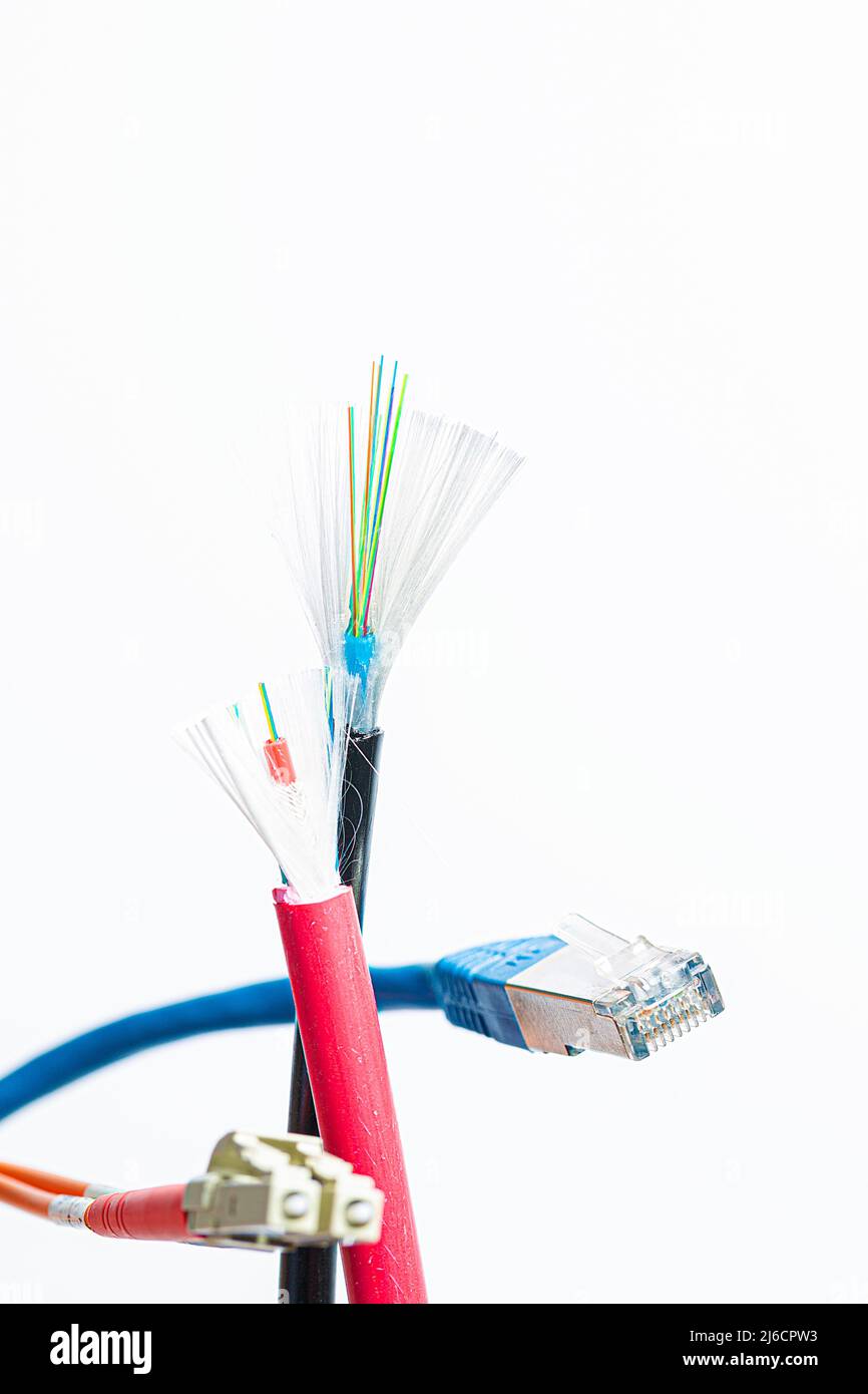 Tagliare il cavo in fibra ottica con connettori in fibra ottica e un cavo patch RJ45 su sfondo bianco Foto Stock