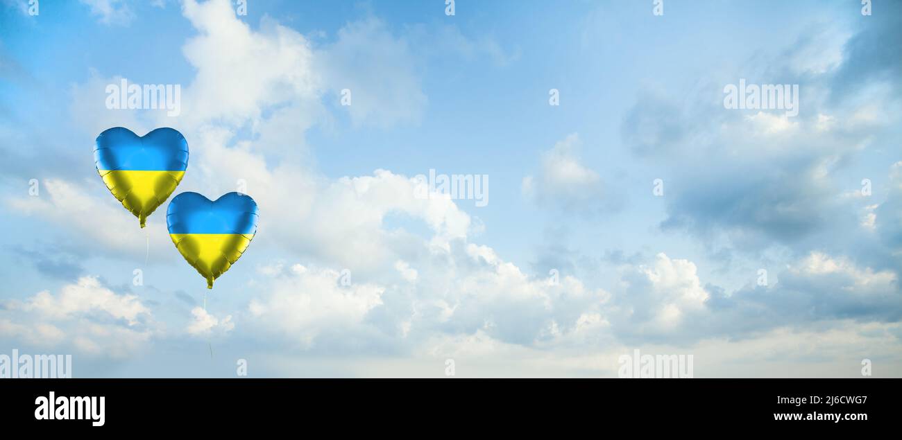 Cielo nuvole sfondo con due palloncini con bandiera Ucraina. Amore Ucraina concetto Foto Stock