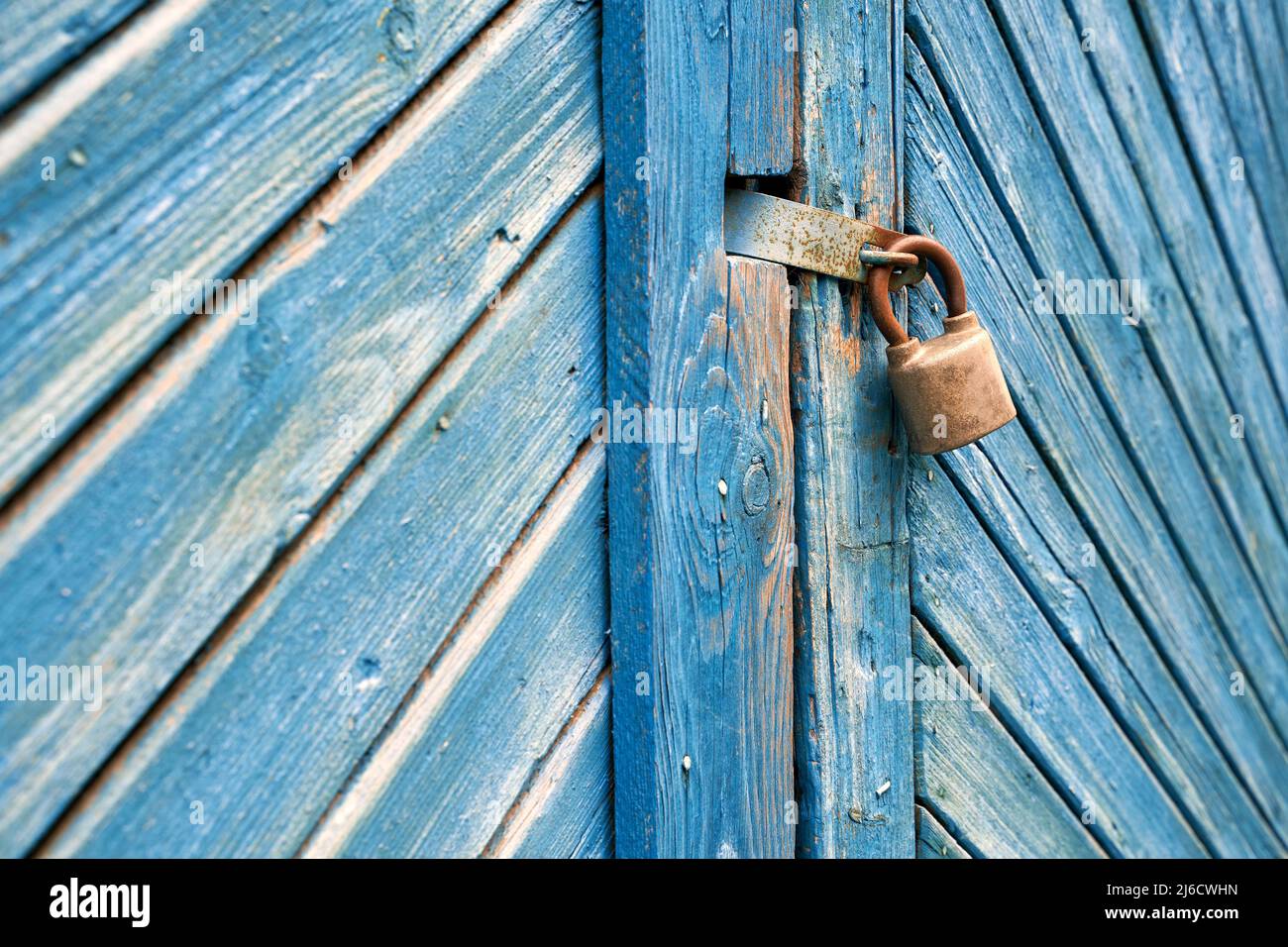 Vecchio lucchetto su una porta in legno blu retrò con intemperie. Sfondo con texture. Foto Stock