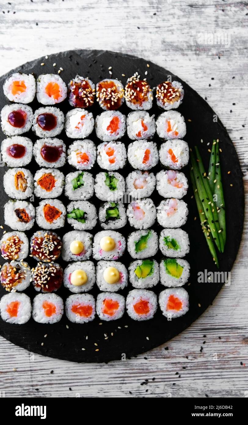 Sushi roll con salmone, tonno, avocado e cetriolo. Cucina tradizionale giapponese. Un sacco di maki. Sushi roll. Vista dall'alto Foto Stock