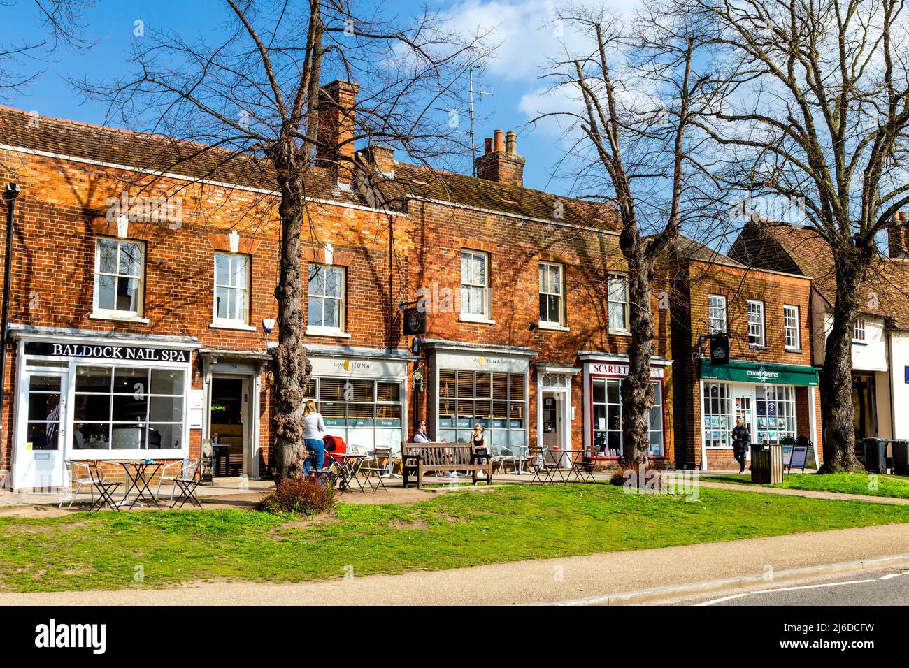 Negozi e caffetterie lungo la High Street a Baldock, Hertfordshire, Regno Unito Foto Stock