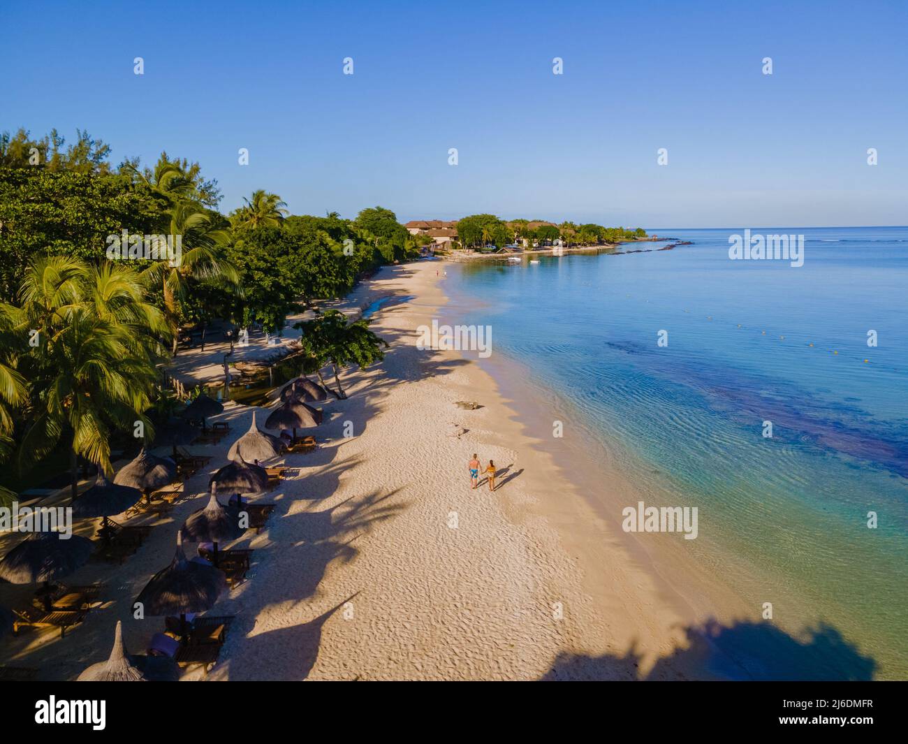 Vista aerea del drone di una spiaggia tropicale, uomini e donne che camminano una spiaggia tropicale a Mauritius. Coppia in vacanza a Mauritius Foto Stock