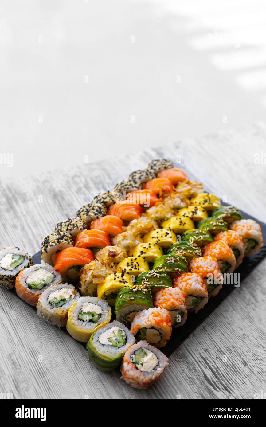 Sushi set nigiri e sushi rotolini su tavola in ardesia di pietra nera. Luogo per tex. Storie instagram Foto Stock