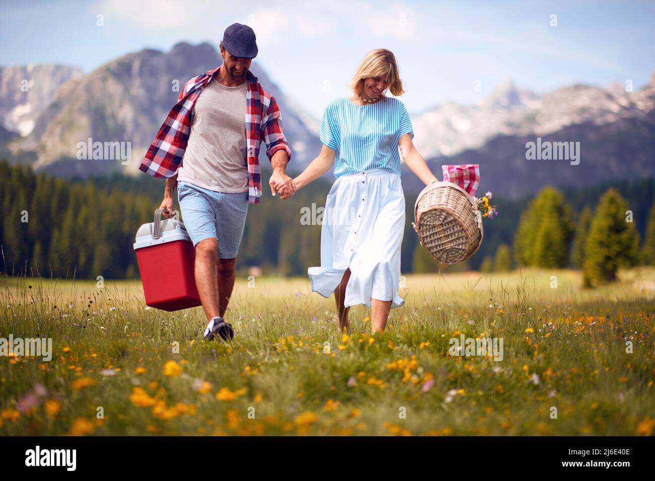 Sorridente giovane uomo e donna che si gode pic-nic in natura. Foto Stock
