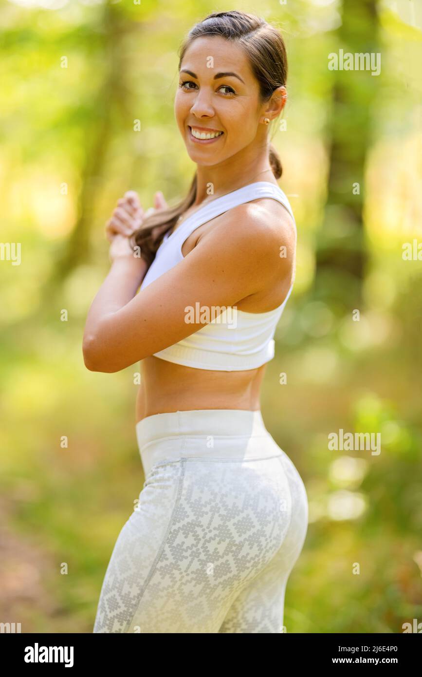 Donna atletica sorridente in Sportswear nella foresta Foto Stock
