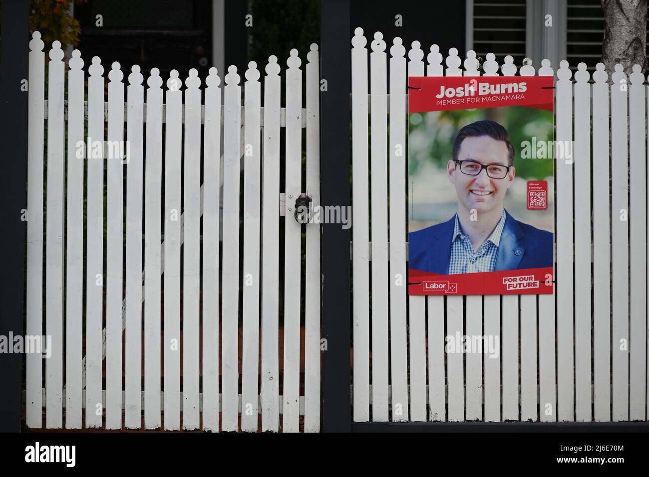 Segno che chiede la rielezione del deputato del Partito laburista australiano, Josh Burns, nell'elettorato di Macnamara, su una recinzione di picket bianco Foto Stock