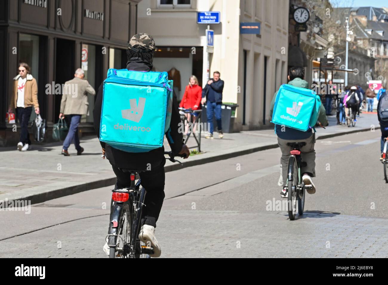 Strasburgo, Francia - Aprile 2022: Consegna persone con zaini per Deliveroo in bicicletta su una strada nel centro di Strasburgo Foto Stock