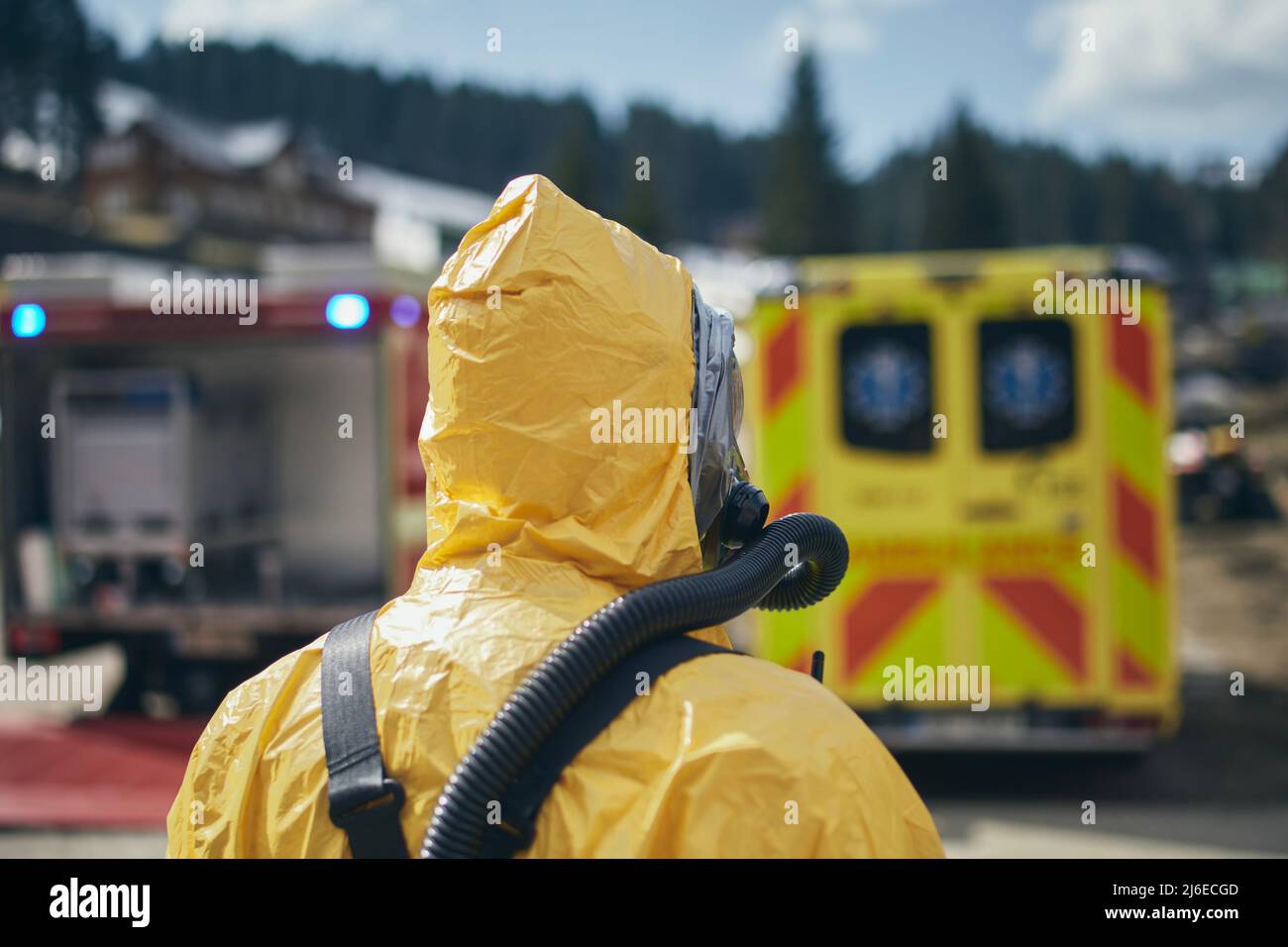 Membro del team di pronto soccorso per il rischio biologico in tuta protettiva contro ambulanza e vigili del fuoco. Foto Stock