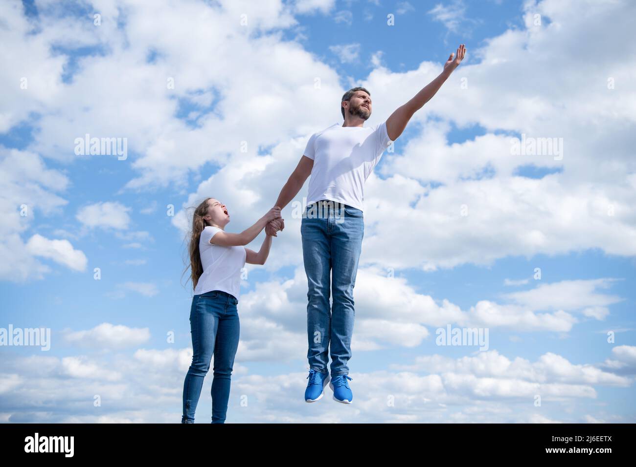 la figlia tiene il suo papà che salta in cielo Foto Stock