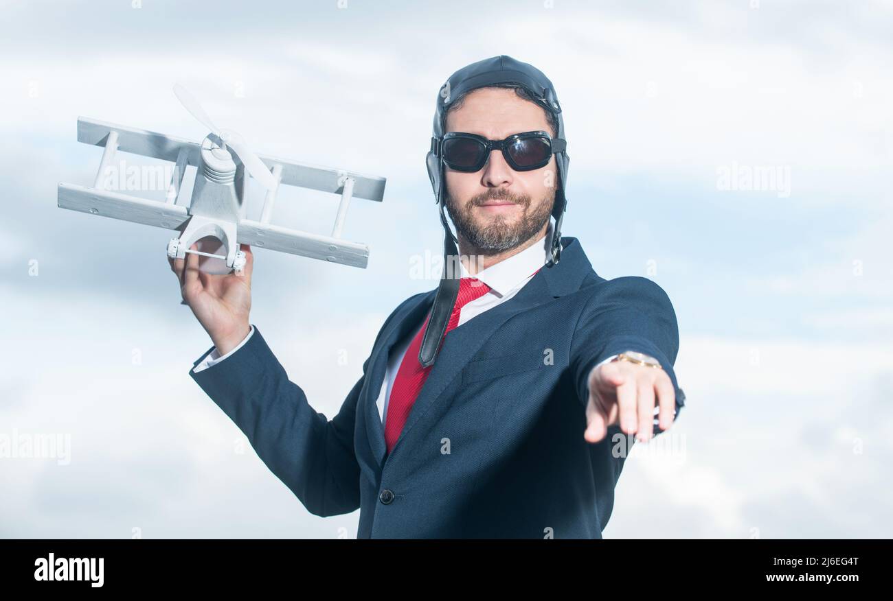uomo d'affari in abito e cappello pilota lancia giocattolo aereo. regia Foto Stock