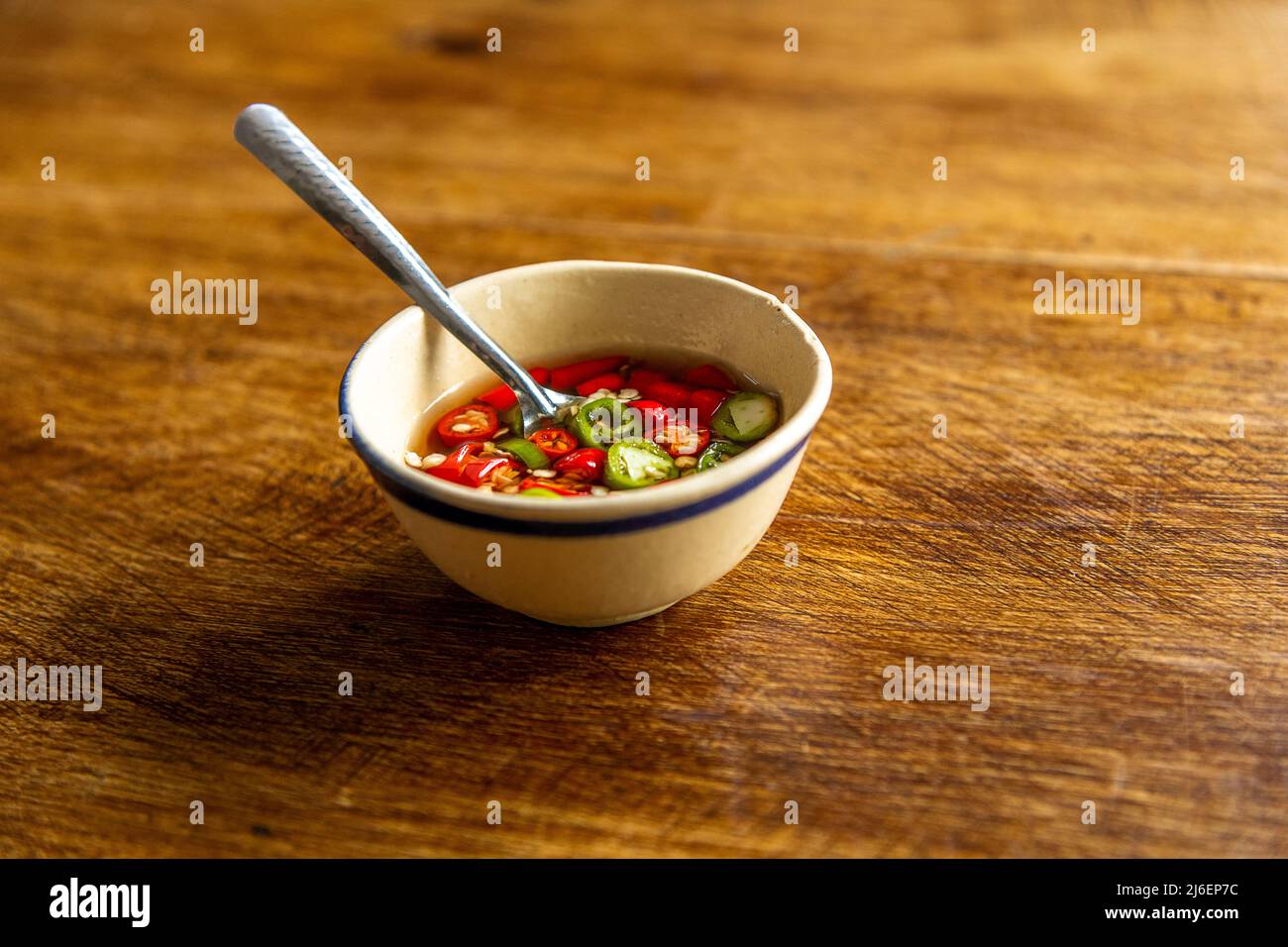 Una piccola ciotola di peperoncini rossi e verdi serviti in Thailandia e Vietnam. Foto Stock
