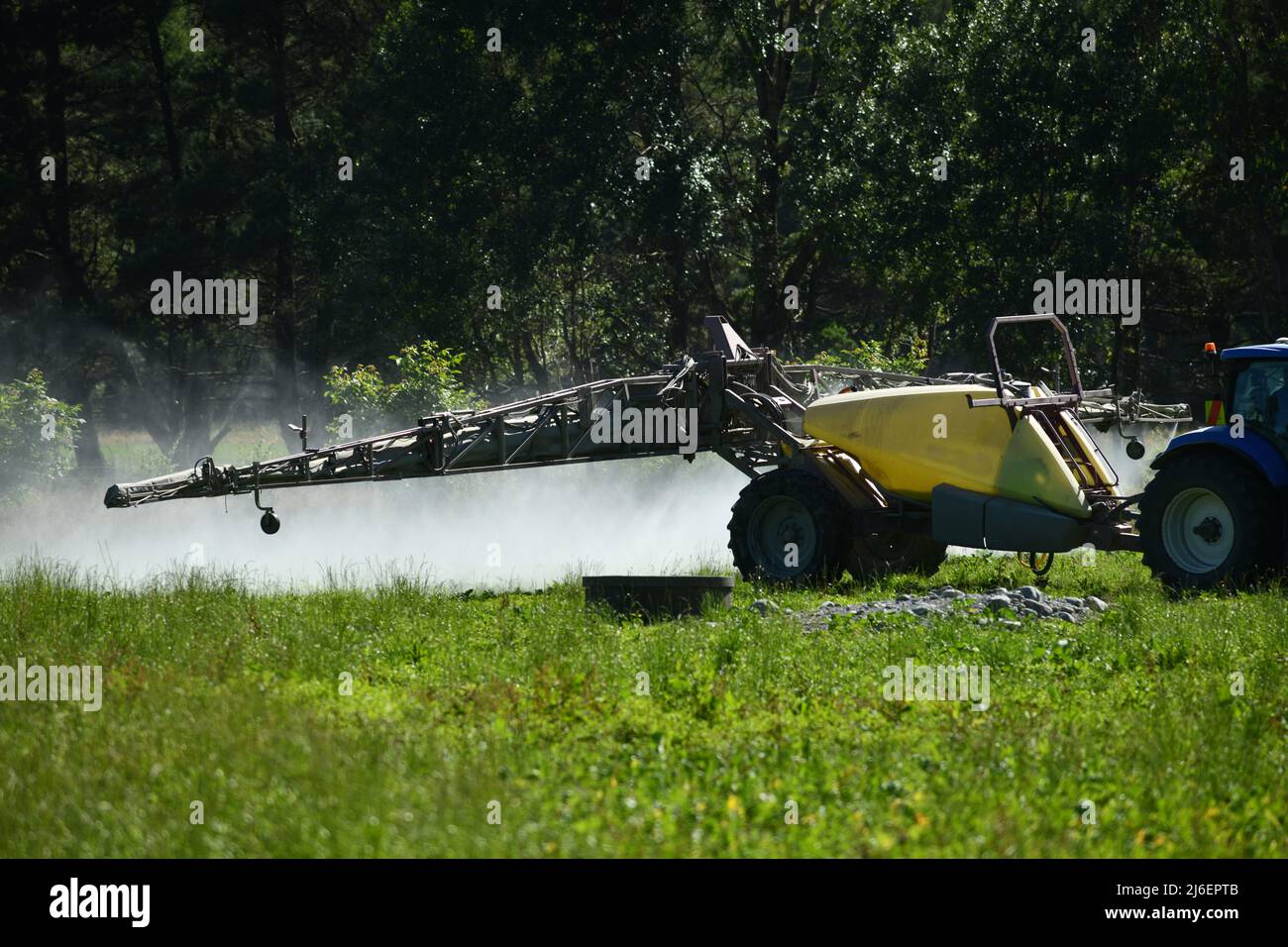 Un coltivatore usa un grande spruzzatore per spargere erbicida su un paddock Foto Stock