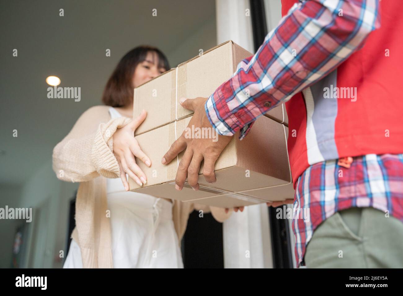 Consegna uomo che consegna scatola a donna. Foto Stock