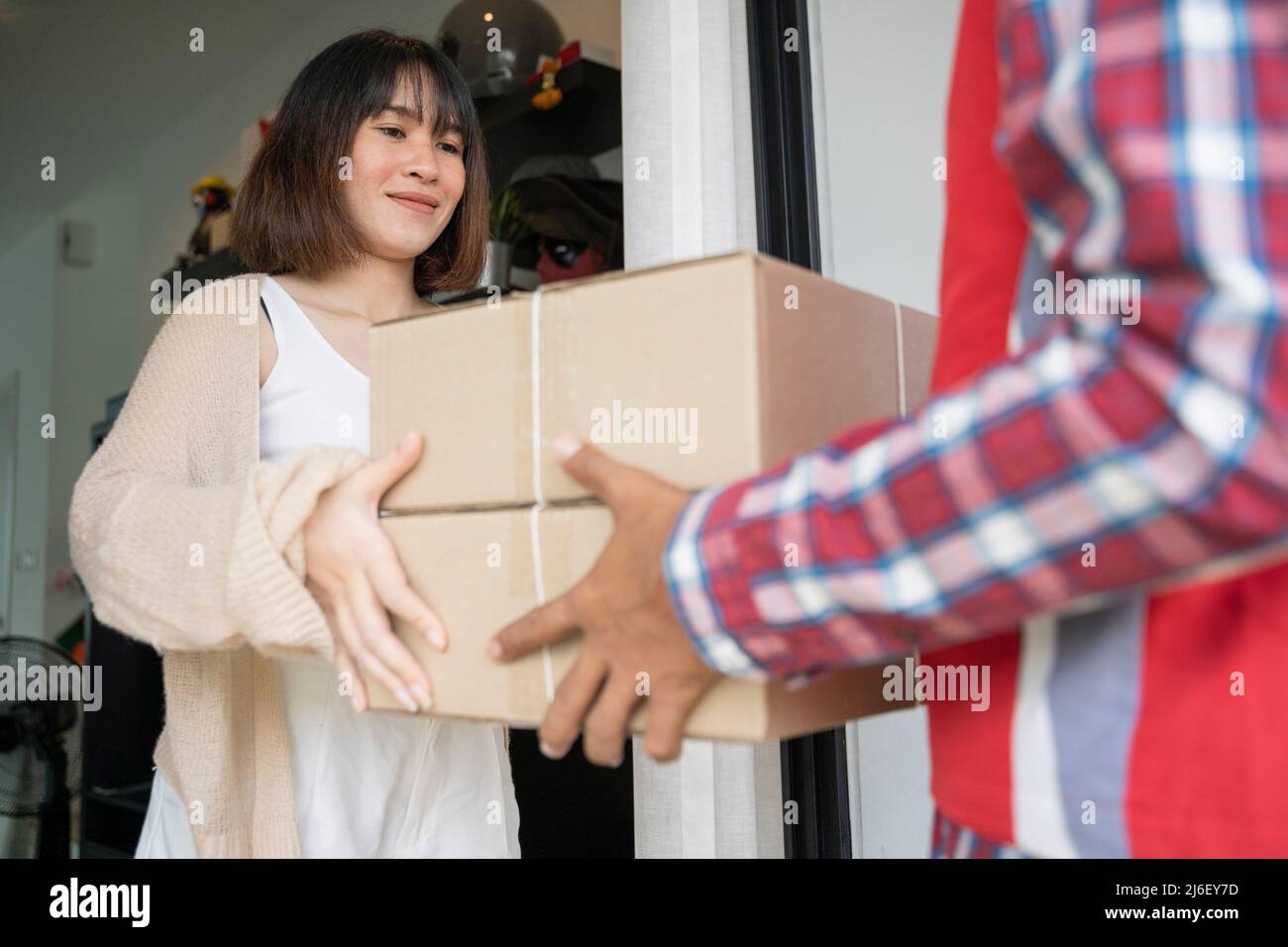 Consegna uomo che consegna scatola a donna. Foto Stock