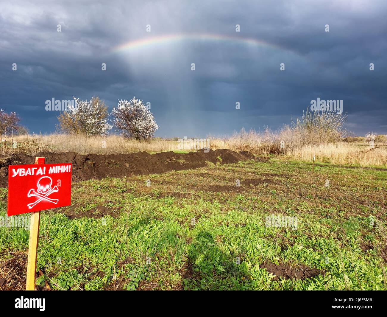 Campo minerario in Ucraina con arcobaleno e cielo drammatico. Guerra in Ucraina Foto Stock