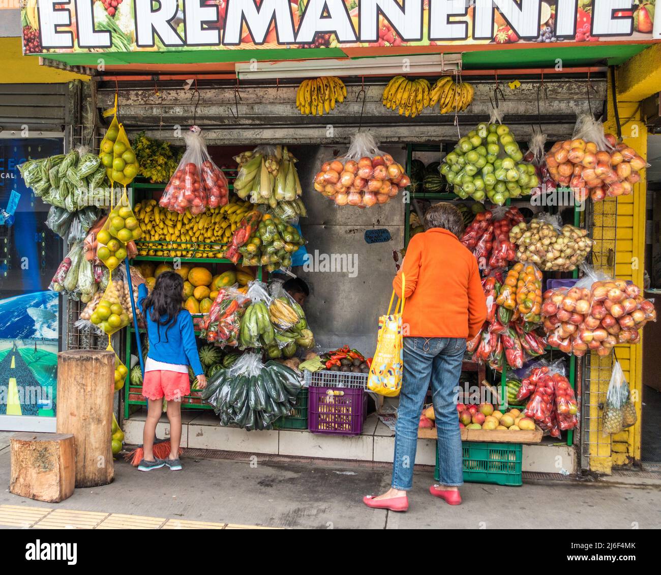 Giovane ragazza con donna adulta che guarda le verdure in un mercato di strada a San José, Costa Rica. Foto Stock