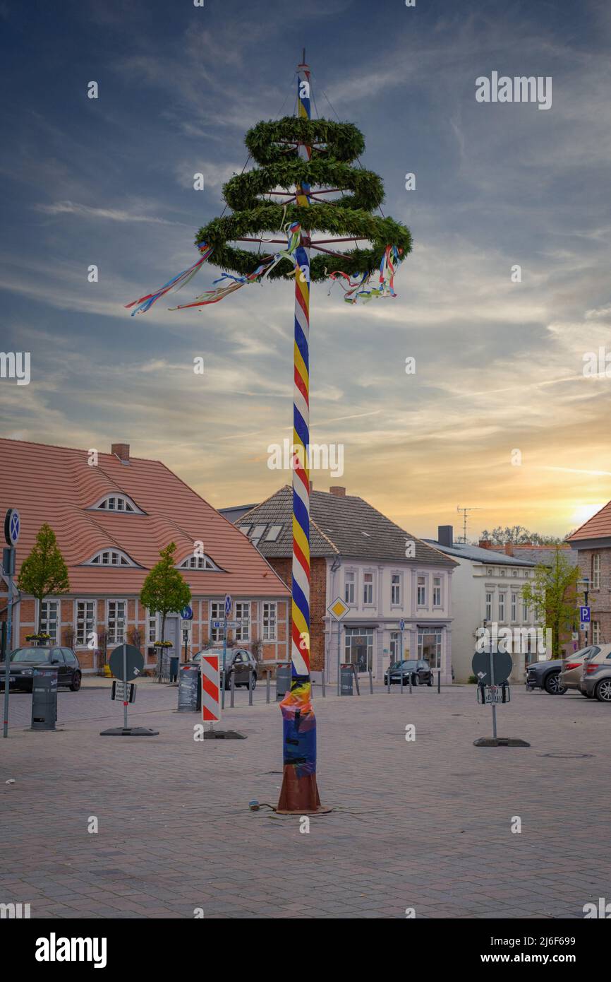 un maypole decorato in maniera colorata si erge su un mercato Foto Stock