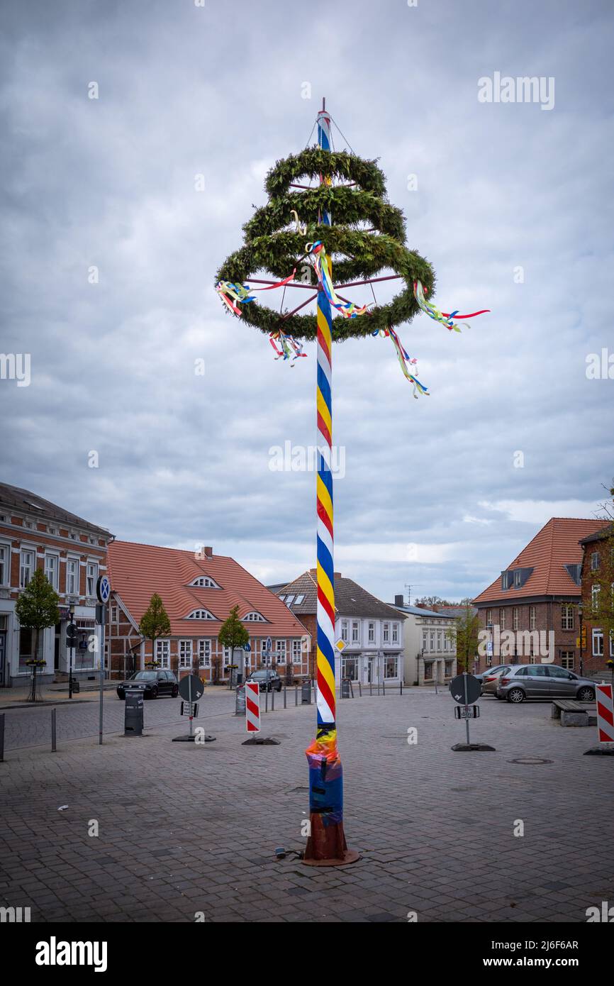 un maypole decorato in maniera colorata si erge su un mercato Foto Stock