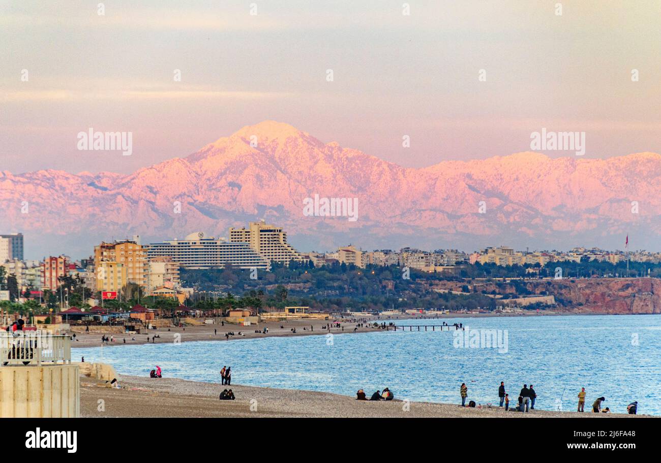 Bagliore alpino nelle cime innevate dei Monti Taurus vista dalla spiaggia di Konyaalti Foto Stock