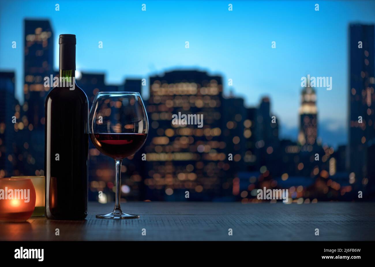 Romantica degustazione di vini rossi con candele e skyline della città di notte Foto Stock