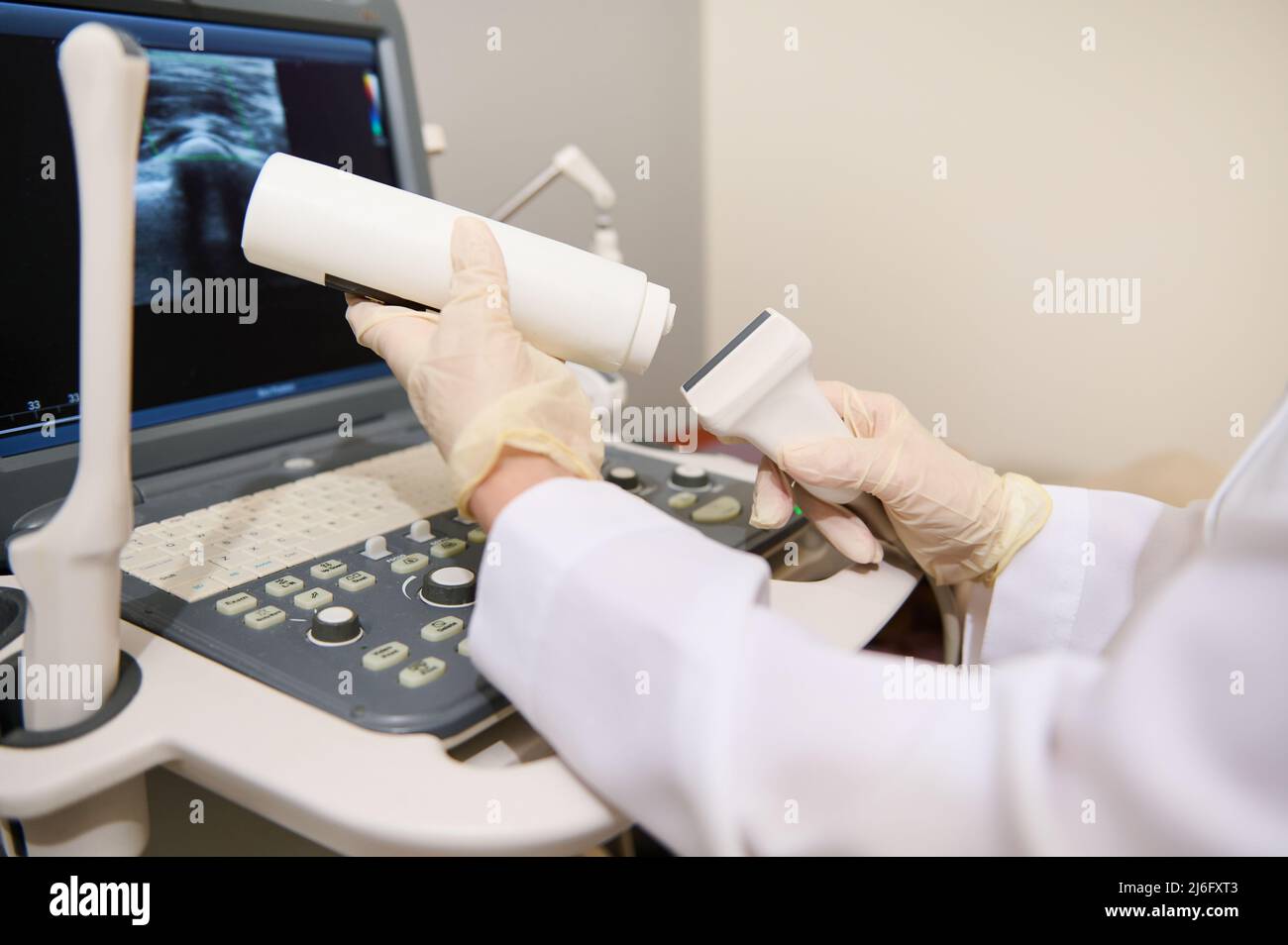 Primo piano della mano di un medico radiologo che tiene in mano un trasduttore a ultrasuoni e un gel di contatto pronto per una diagnosi. Ultrasonografia. USG Foto Stock