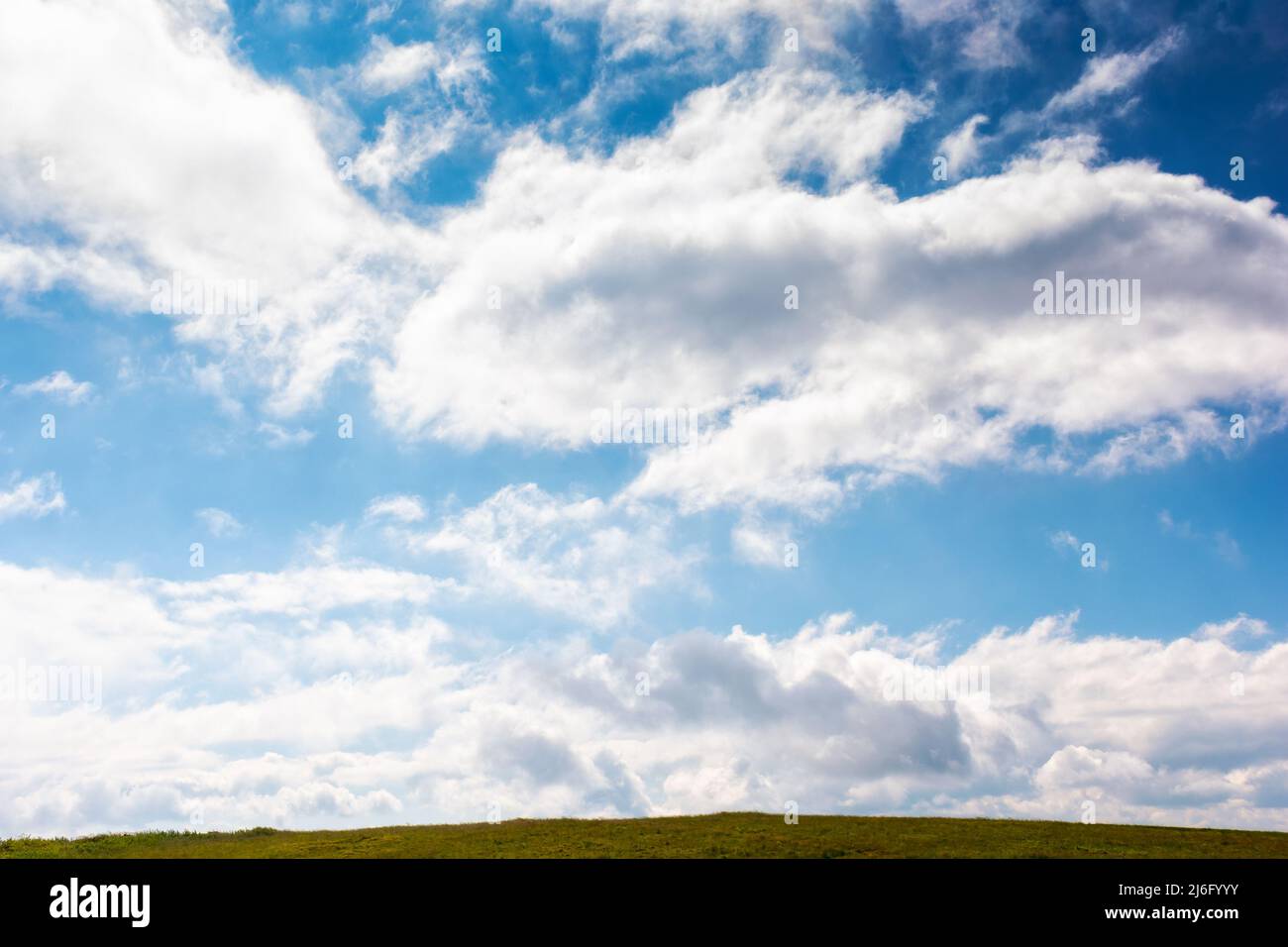 cielo nuvoloso sopra il prato verde. paesaggio naturale con linea d'orizzonte. bellissimo paesaggio al mattino Foto Stock