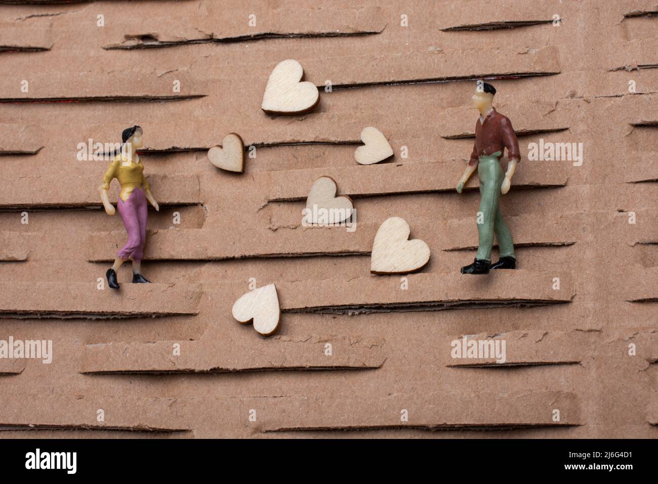 Minuscola figurina di uomo e donna modello in miniatura e cuore come concetto di amore Foto Stock