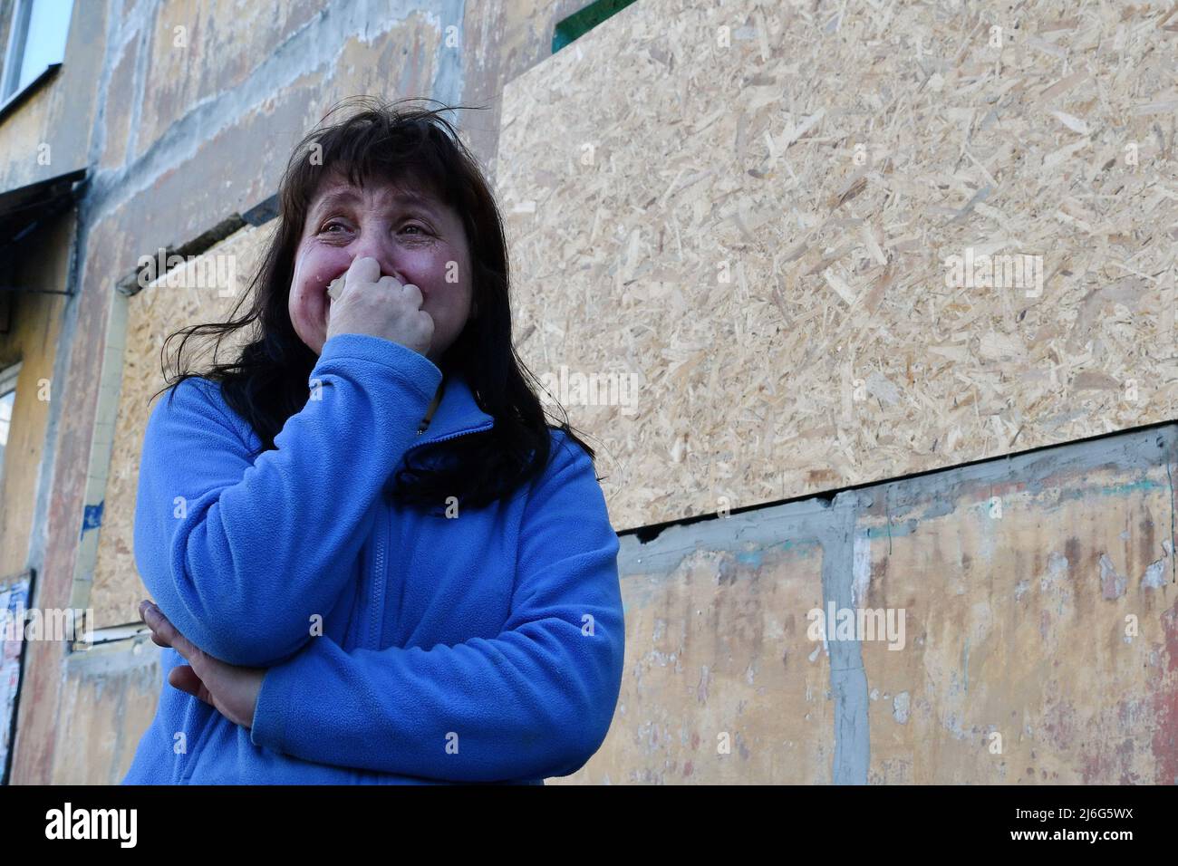 Elena, 51 anni, si vede piangere accanto alla finestra rovinata del suo appartamento danneggiato da un bombardamento russo a Dobropillya. La Russia è stata costretta a spostare forze 'disparate e disparate' nell'Ucraina orientale, secondo l'ultimo rapporto di intelligence del Ministero della Difesa del Regno Unito di sabato. Il Regno Unito ha affermato che "probabilmente queste unità soffrono di un morale indebolito". Foto Stock