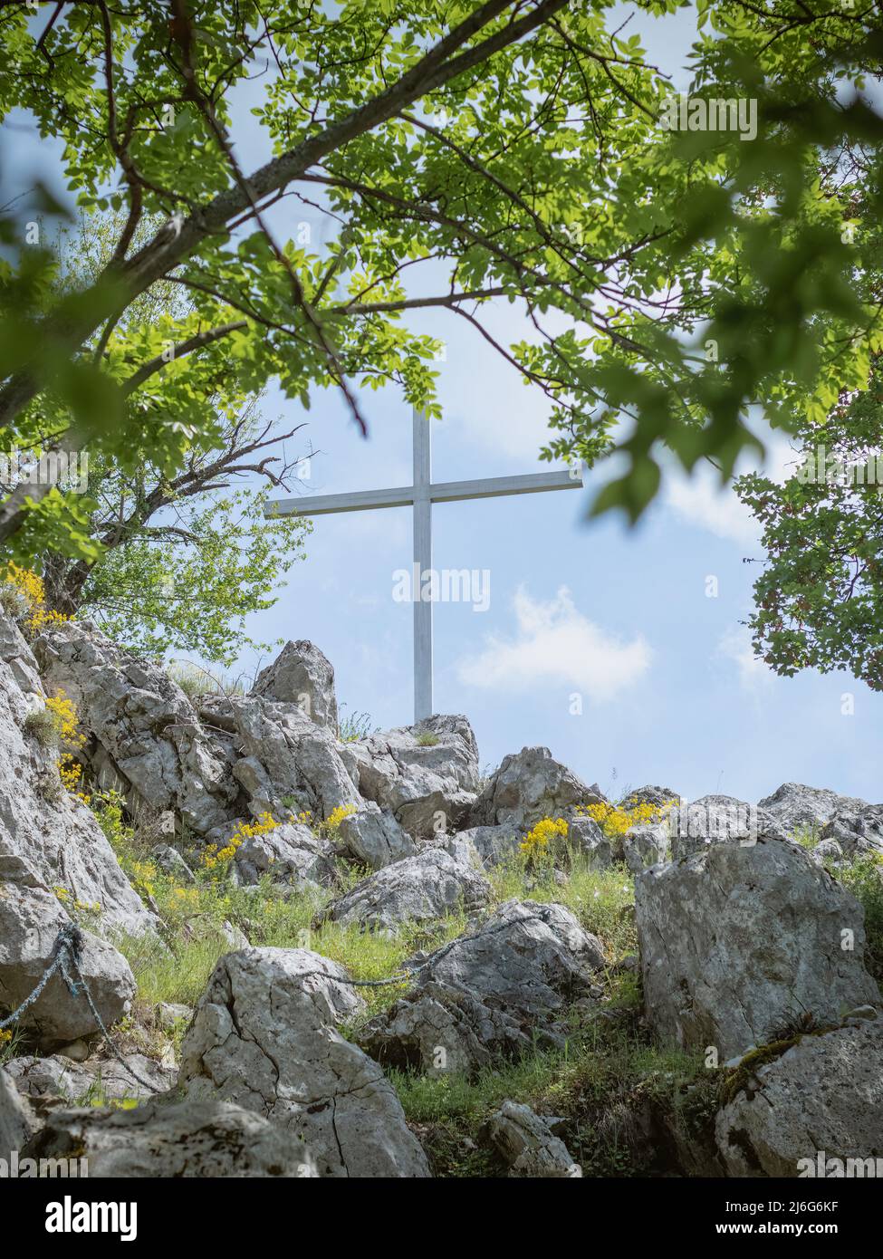 Vista della Croce in cima alla collina, pellegrinaggio, religione. Montagna e foresta. Foto Stock