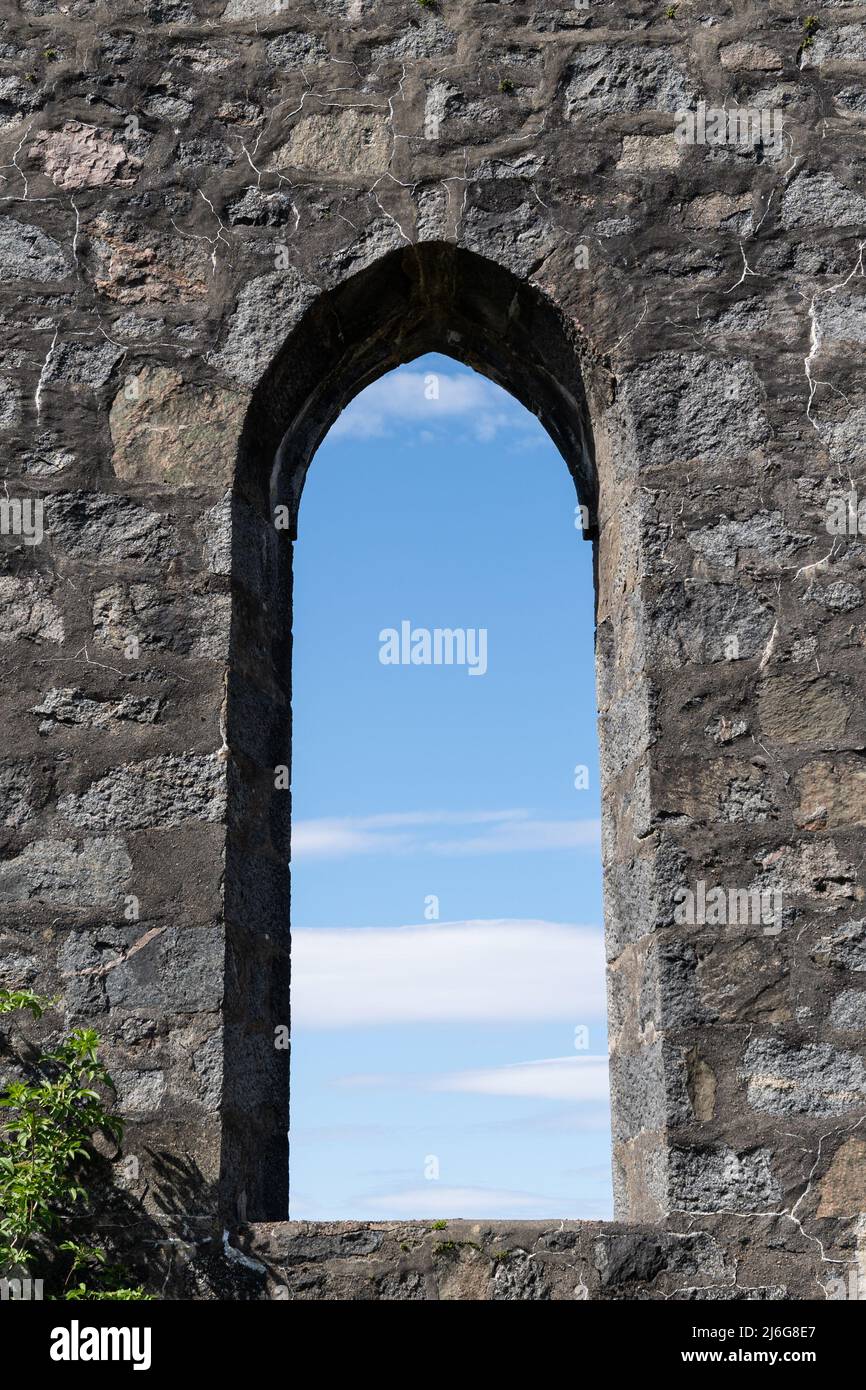 Antica arcata in pietra che incornicia il cielo blu nelle rovine del castello scozzese Foto Stock