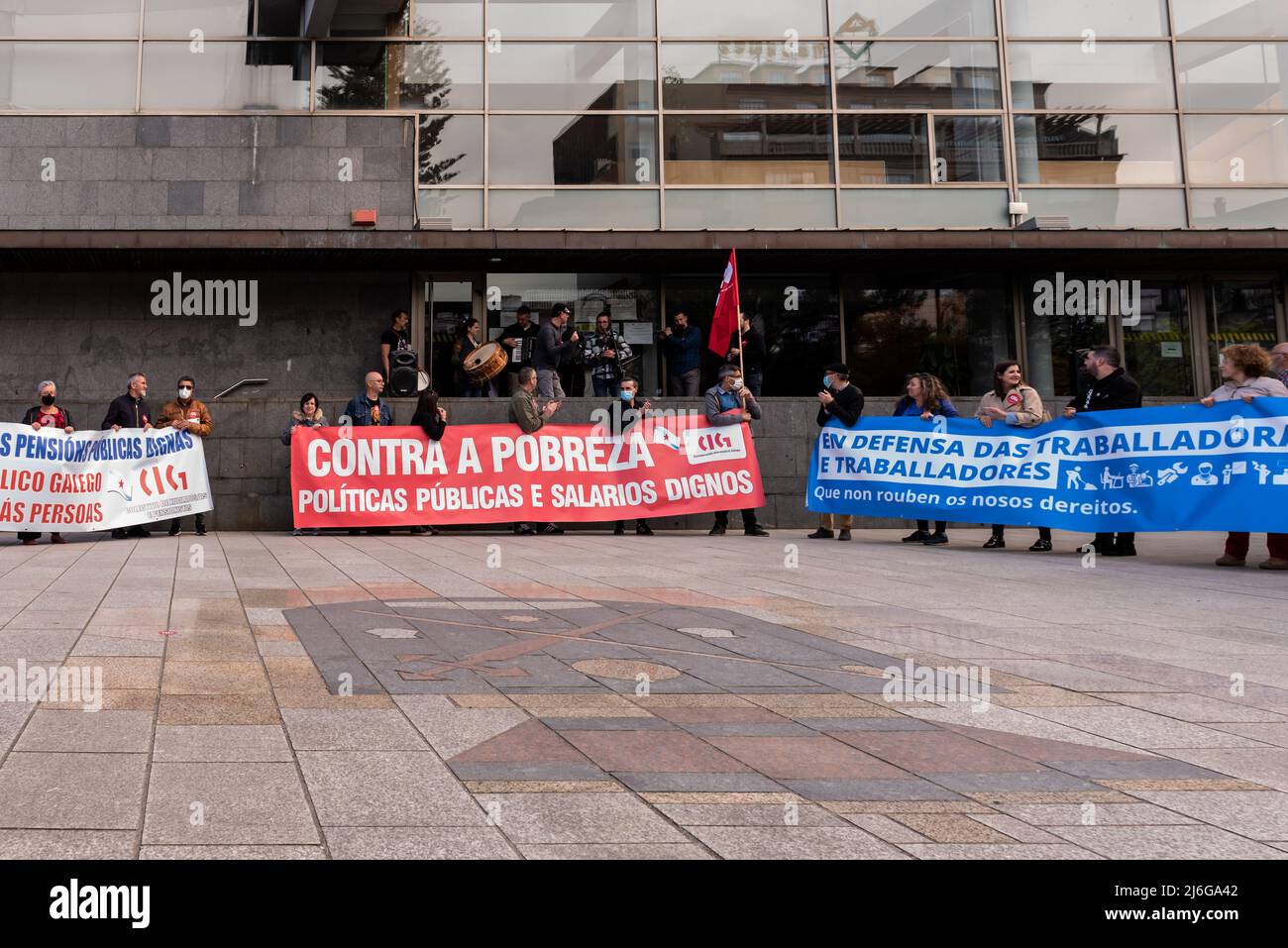 CANGAS, PONTEVEDRA, SPAGNA - 01 maggio 2022: I manifestanti della giornata del lavoro con le bandiere fuori del municipio come un discorso è tenuto Foto Stock