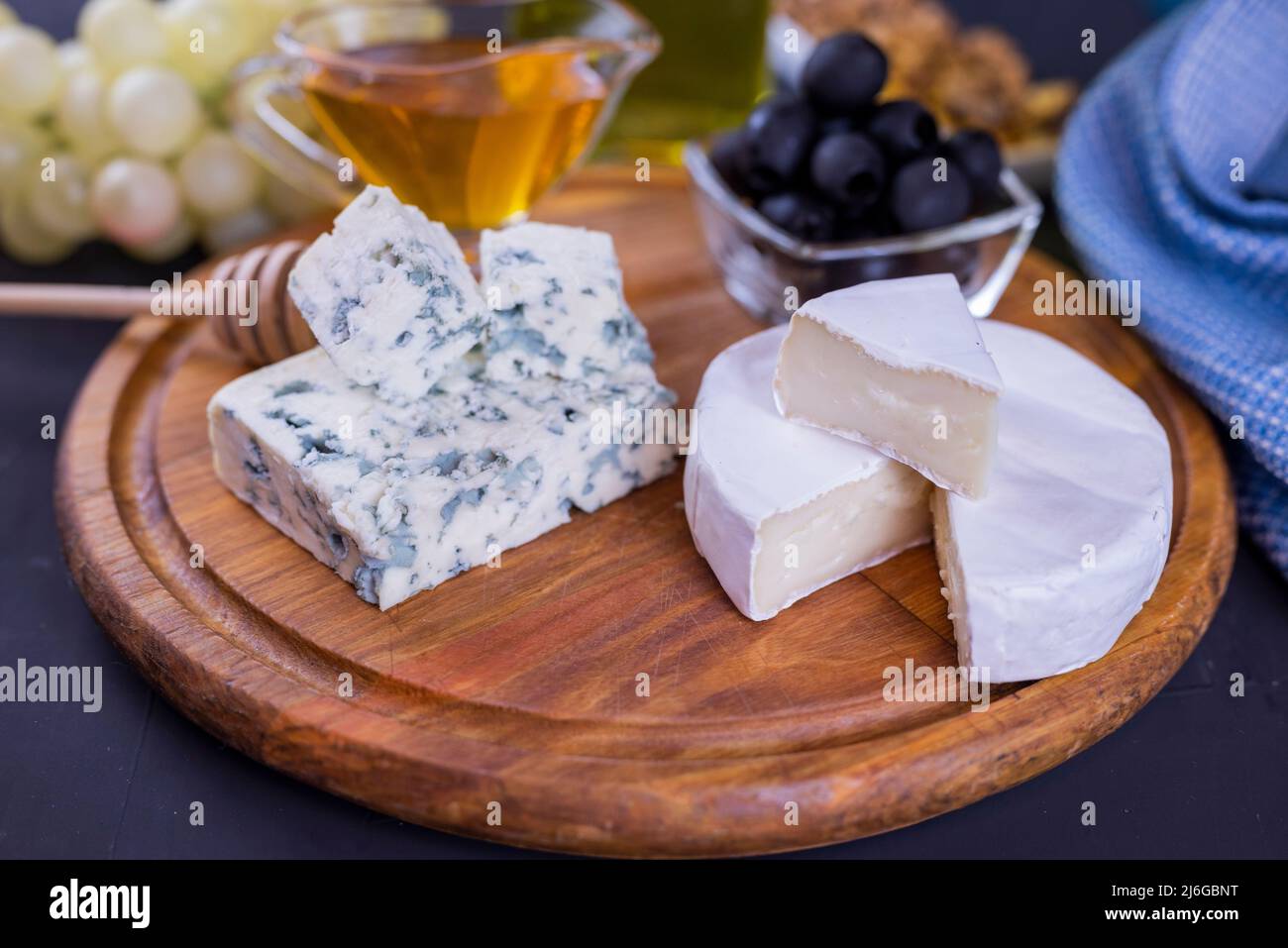 antipasto formaggio dor blu e camembert su un bordo di legno con miele e uva Foto Stock