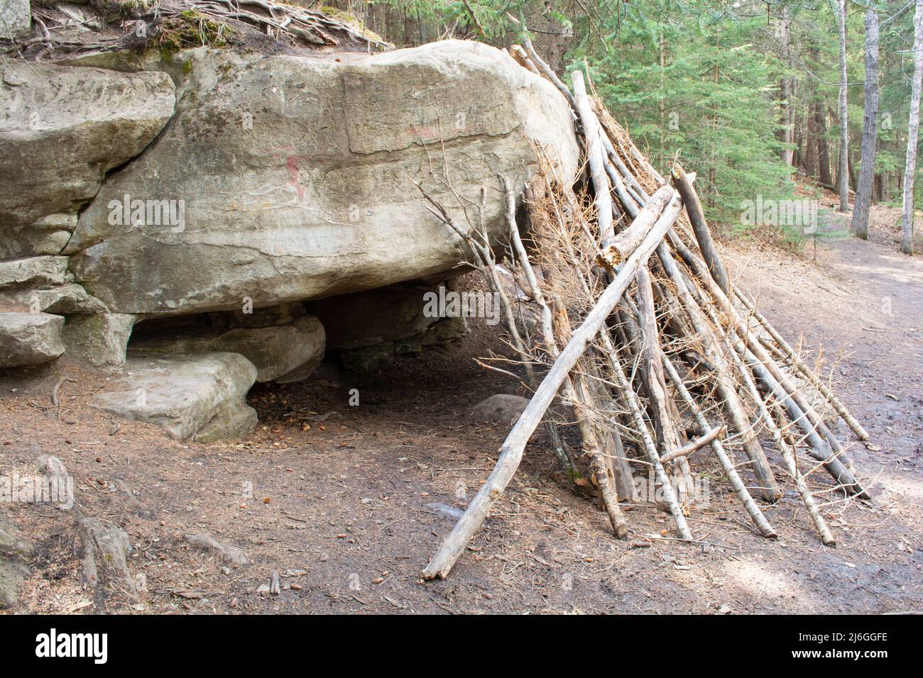 Ricovero in legno su caverna di roccia sovrastante. Foto Stock