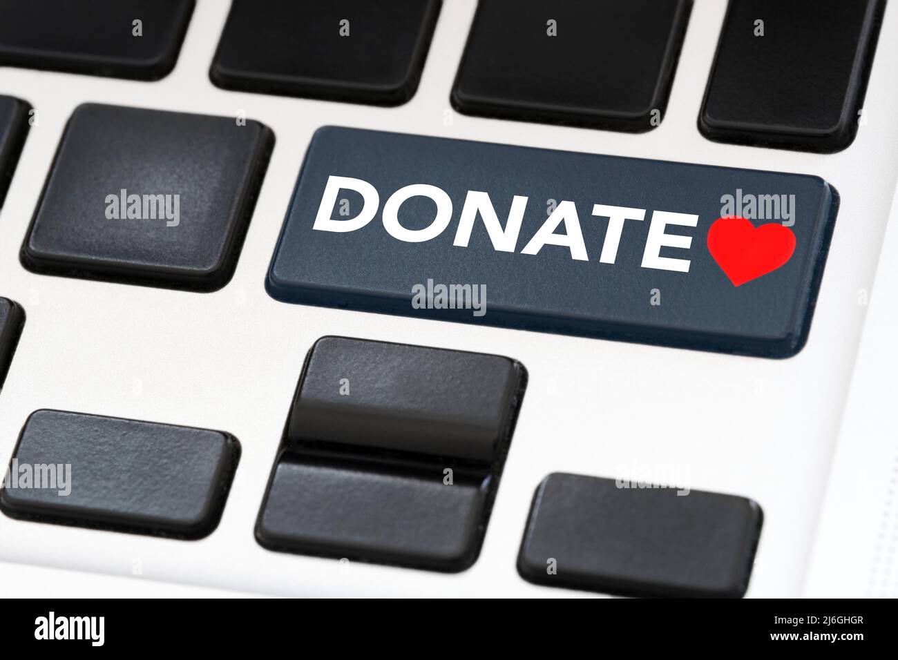Tasto della tastiera con la parola Donate e un cuore rosso. Concetti: Solidarietà, sostegno alle cause caritative, aiuto alle vittime di catastrofi, rifugiati, persone provenienti da Foto Stock