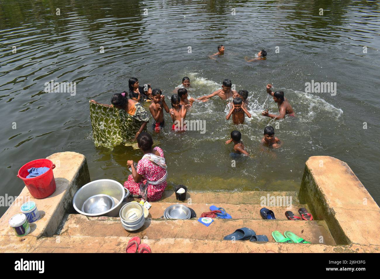 1 maggio 2022, Kolkata, Bengala Occidentale, India: La gente sta bagnando e lavando i loro panni, utensili all'interno di un laghetto in una calda giornata estiva alla periferia di Kolkata. (Credit Image: © Sudipta Das/Pacific Press via ZUMA Press Wire) Foto Stock