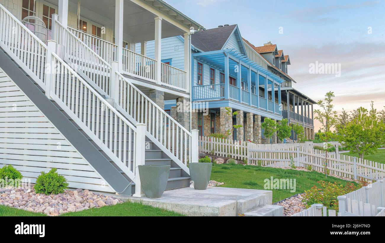 Panorama Whispy nuvole bianche tre grandi case con recinzione di picket bianco e verande all'ingresso di Daybreak, Utah Foto Stock