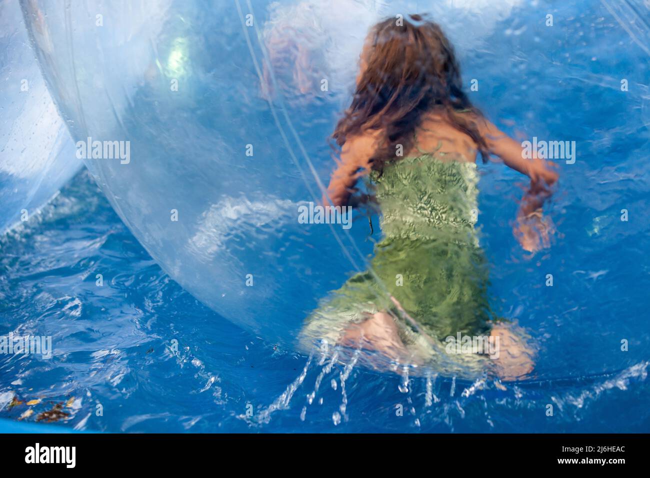 Giovane ragazza in una bolla di plastica trasparente che galleggia sull' acqua in un'attrazione della Foire du Midi, a Bruxelles Foto stock - Alamy