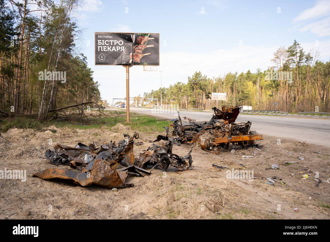 Camion distrutto si trova accanto a una delle strade principali di Kiev nel mese di aprile 2022 Foto Stock