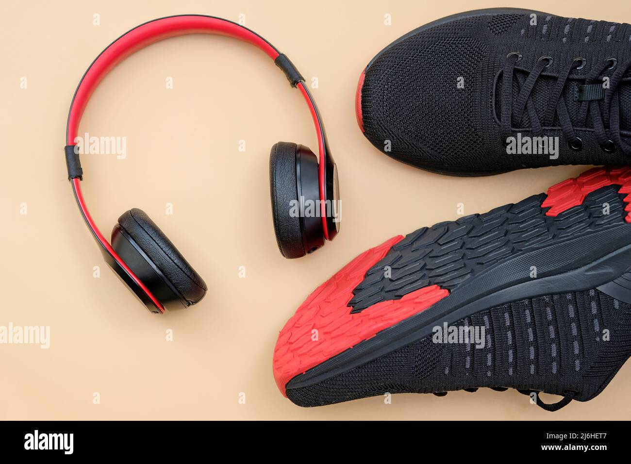 Cuffie sneakers rosse e nere su sfondo beige vista dall'alto. Attività  sportive con musica. Eleganti cuffie wireless con scarpe sportive Foto  stock - Alamy