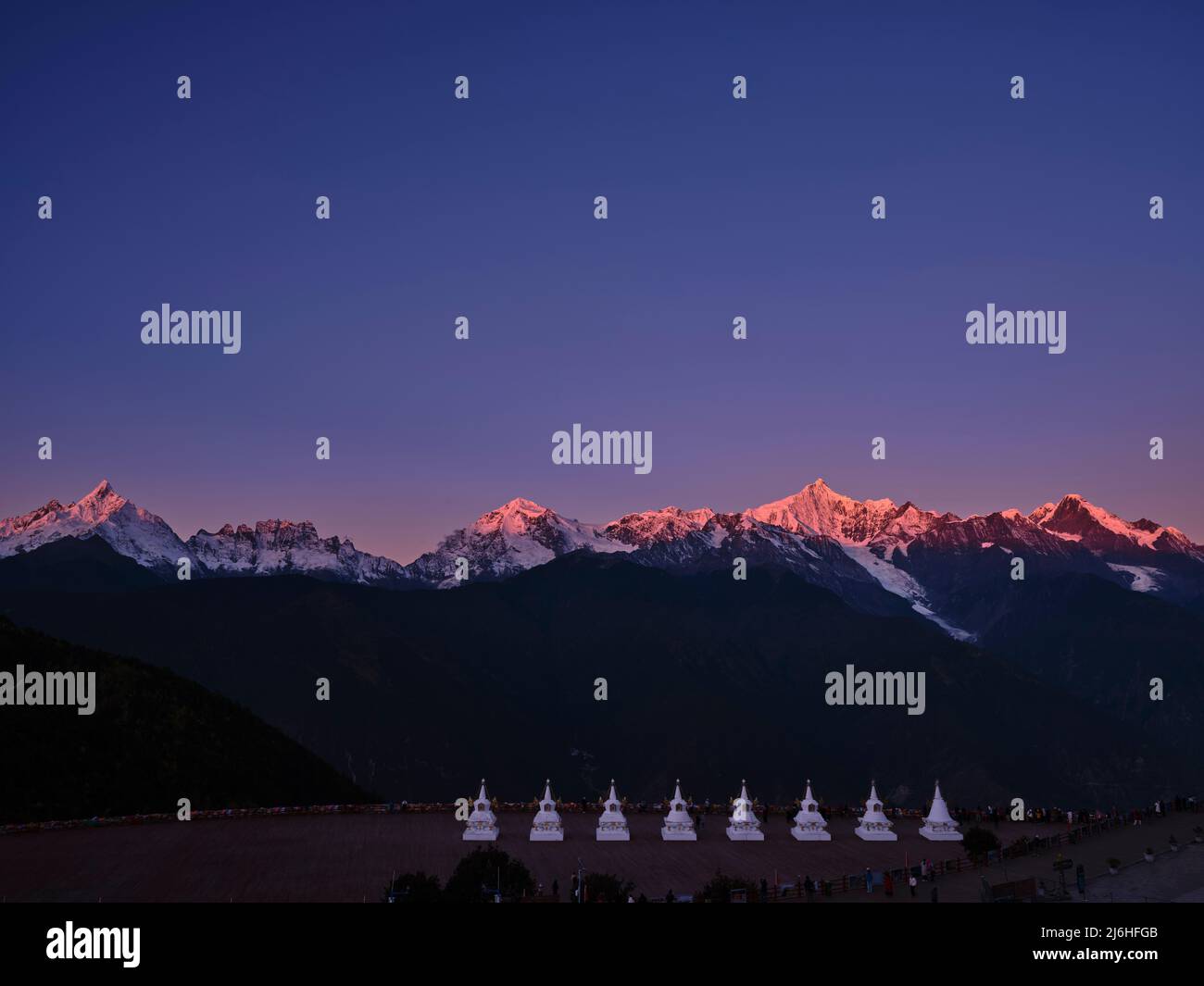 pagode bianche di tempio feilai con montagna di neve meili all'alba sullo sfondo nella provincia cinese di yunnan Foto Stock