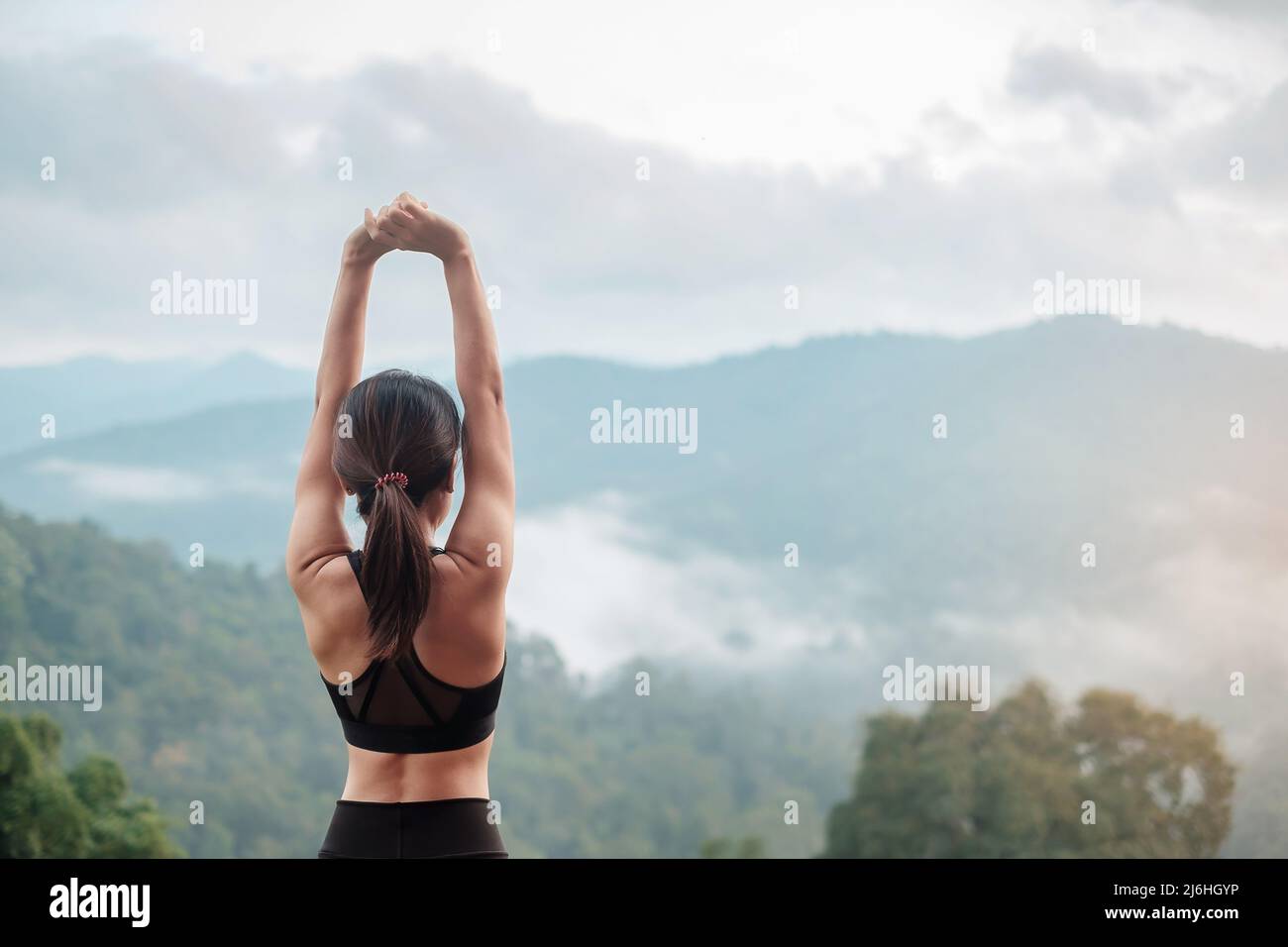 Atleta donna esercizio al mattino, giovane donna fitness stretching muscolo contro vista montagna, riscaldamento pronto per correre o jogging. Allenamento, wellbei Foto Stock